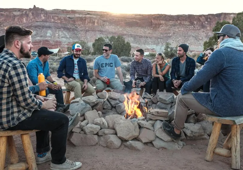 Friends talking around a campfire