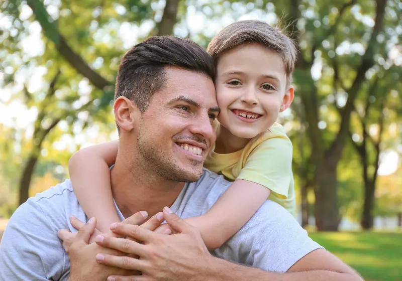 A father hugging his son outdoors