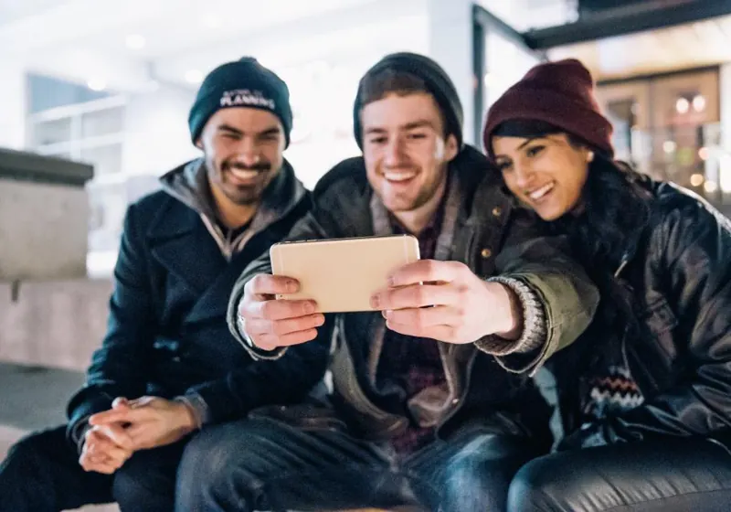 Three friends looking at a phone together
