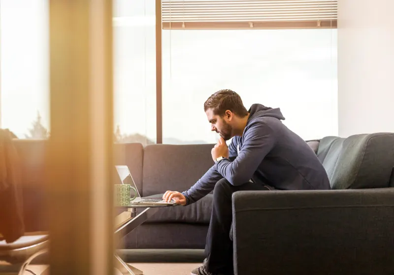 A man sitting alone at home, deep in thought